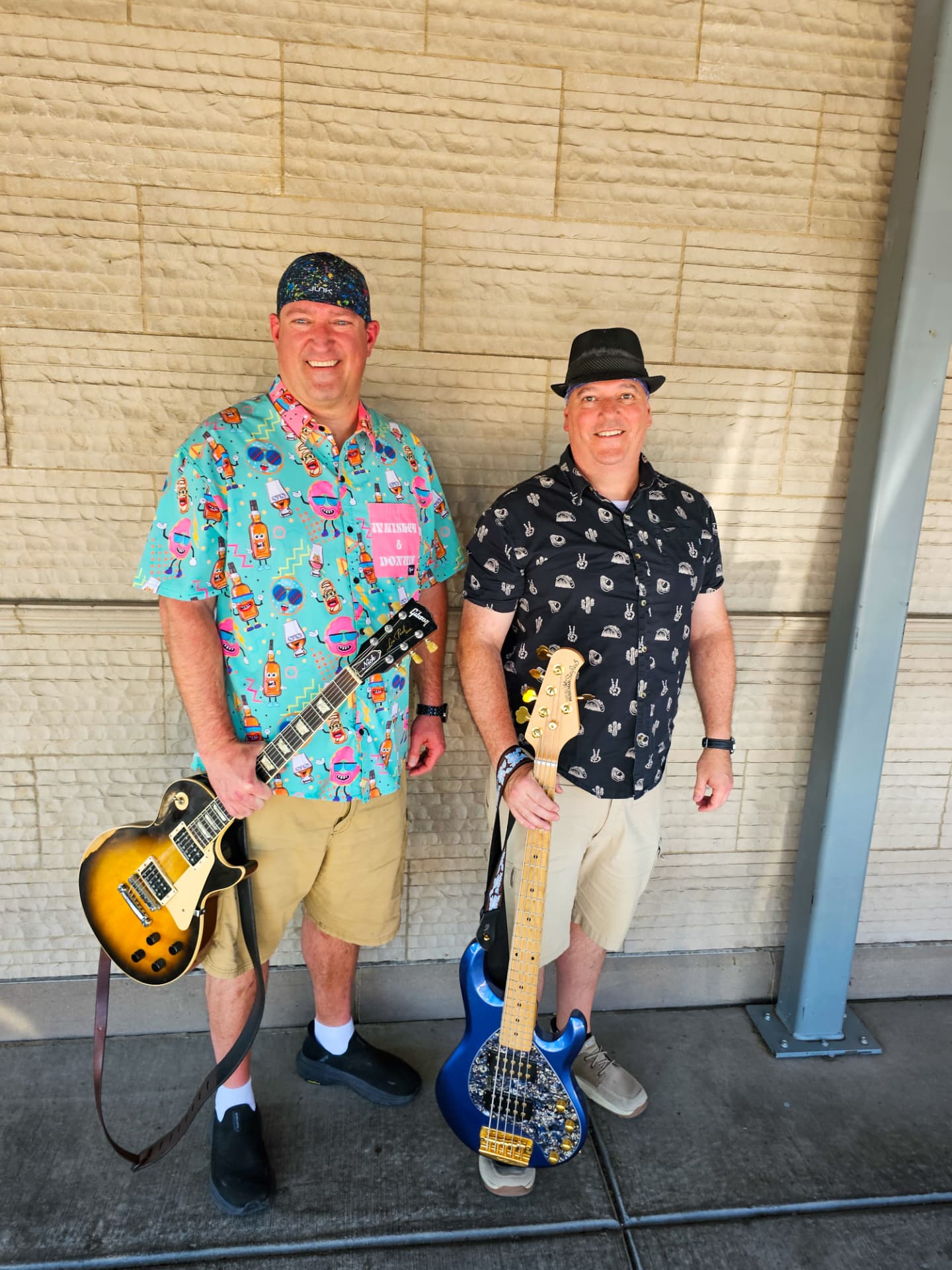 Eric and Nick holding their Les Paul and blue bass guitars